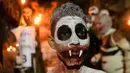 Peserta berdandan seperti hantu saat mengikuti parade La Calabiuza di Tonacatepeque, El Salvador (1/11). Selama perayaan, penduduk Tonacatepeque mengingat kembali karakter dari mitologi Cuscatlan. (AFP Photo/Marvin Recinos)