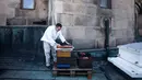 Peternak lebah, Uwe Marth membuka kotak sarang lebah madu yang diproduksi di atap Katedral Berlin di Berlin, 14 Mei 2018. Seseorang tidak akan mengira kalau ibu kota Jerman itu adalah lokasi ideal beternak lebah dan produksi madu. (AP/Markus Schreiber)