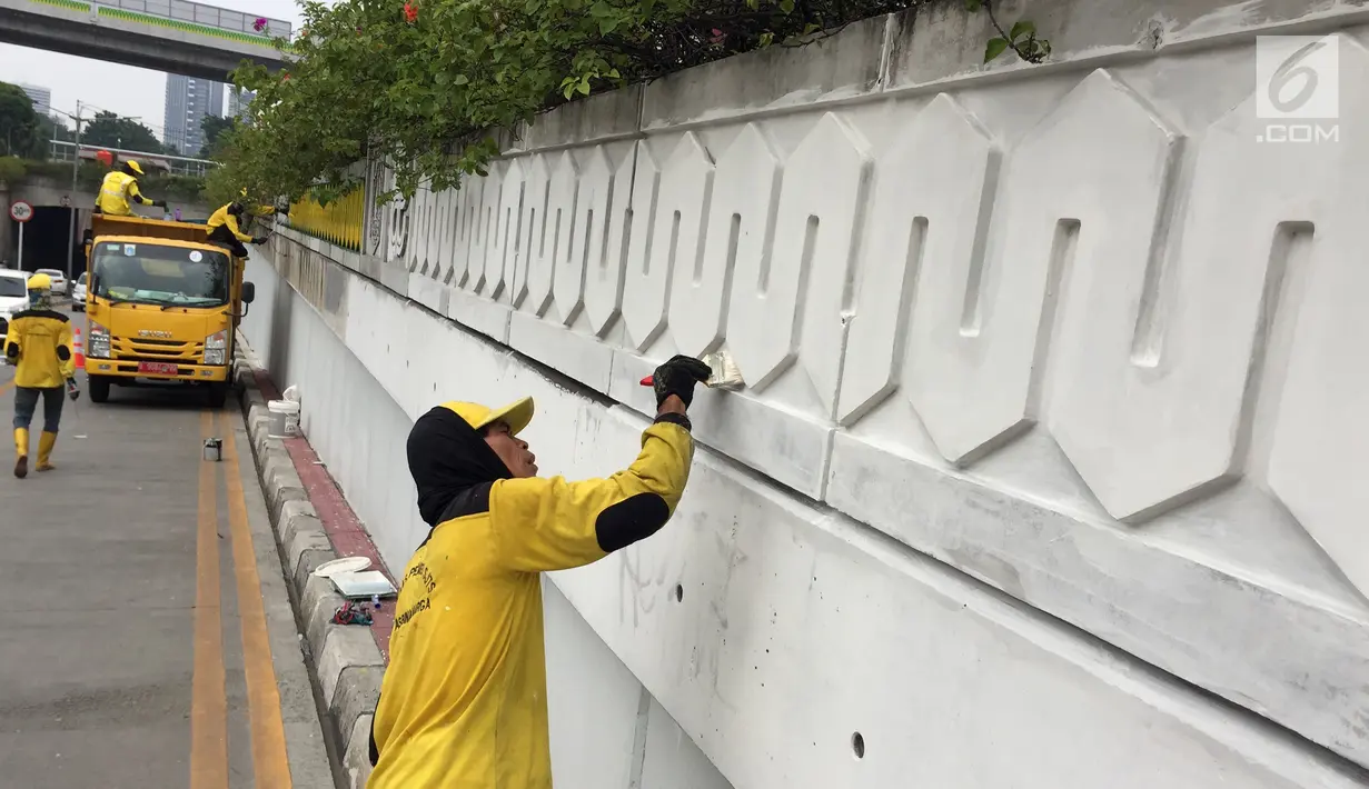 Suasana saat Pasukan Kuning mengecat dinding Underpass Kebayoran Baru, Jakarta Selatan, Kamis (1/2). Pengecatan dilakukan agar dinding underpass tidak kusam serta menghindari kesan kumuh. (Liputan6.com/Immanuel Antonius)