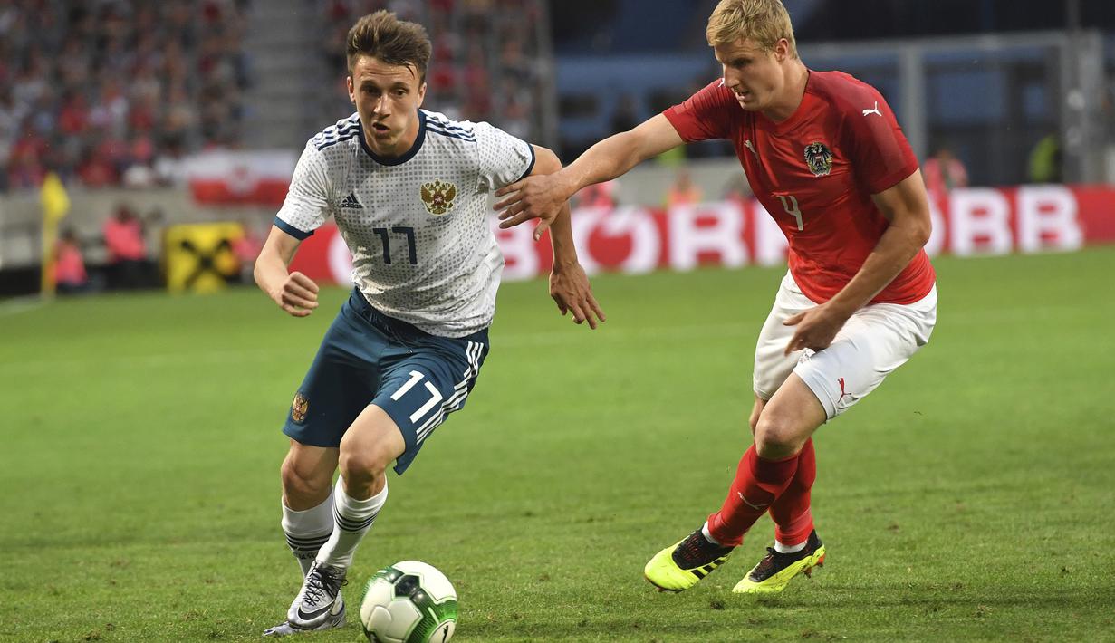 Pemain Austria, Martin Hinteregger (kanan) berusaha menahan laju pemain Russia, Alexandr Golovin pada laga uji coba di Tivoli Stadium, Innsbruck, Austria, (30/5/2018). Austria menang atas Rusia 1-0. (AP/Kerstin Joensson)