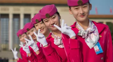 Para pemandu berpose  di lapangan Tiananmen selama sesi penutupan Kongres Partai Komunis ke-19 di Beijing (24/10). Sejumlah wanita cantik ini ditugaskan untuk memandu para peserta kongres. (AFP Photo/ Nicolas Asfouri)