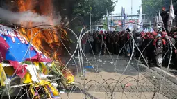 Karangan bunga untuk Ahok-Djarot dibakar oleh orang yang diduga menjadi provokasi saat aksi Hari Buruh di Jalan Medan Merdeka Barat, Jakarta, Senin (1/5). (Liputan6.com/Yoppy Renato)