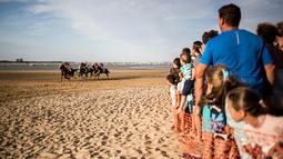 Sejumlah joki memacu kuda mereka pada lomba pacuan kuda di sepanjang pantai di Sanlucar de Barrameda, Spanyol pada 11 Agustus 2019. Balap kuda di tepi pantai ini merupakan acara tahunan yang telag berlangsung selama lebih dari 140 tahun. (AP Photo/Javier Fergo)
