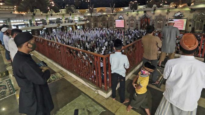 Umat Muslim berdoa terpisah dengan mengenakan masker selama salat Idul Adha di sebuah masjid di Jakarta, Indonesia, 31 Juli 2020. Idul Adha, atau Pesta Kurban, ditandai dengan mengorbankan hewan untuk memperingati iman Nabi Ibrahim karena bersedia mengorbankan putranya. (AP Photo/Tatan Syuflana)