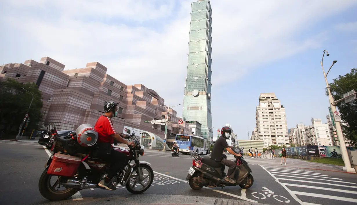 <p>Warga memakai masker untuk melindungi diri dari penyebaran COVID-19 saat melewati Gedung Taipei 101 di Taipei, Taiwan, Sabtu (15/5/2021). Pandemi COVID-19 di Taiwan naik ke level tiga. (AP Photo/Chiang Ying-ying)</p>