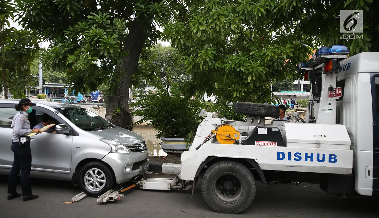 Mobil Dinas Perhubungan bersiap menderek kendaraan yang terjaring parkir liar di kawasan Pasar Baru, Jakarta, Kamis (14/12). Meskipun sering ditertibkan, namun masih banyak pengendara yang nekat parkir sembarangan. (Liputan6.com/Immanuel Antonius)
