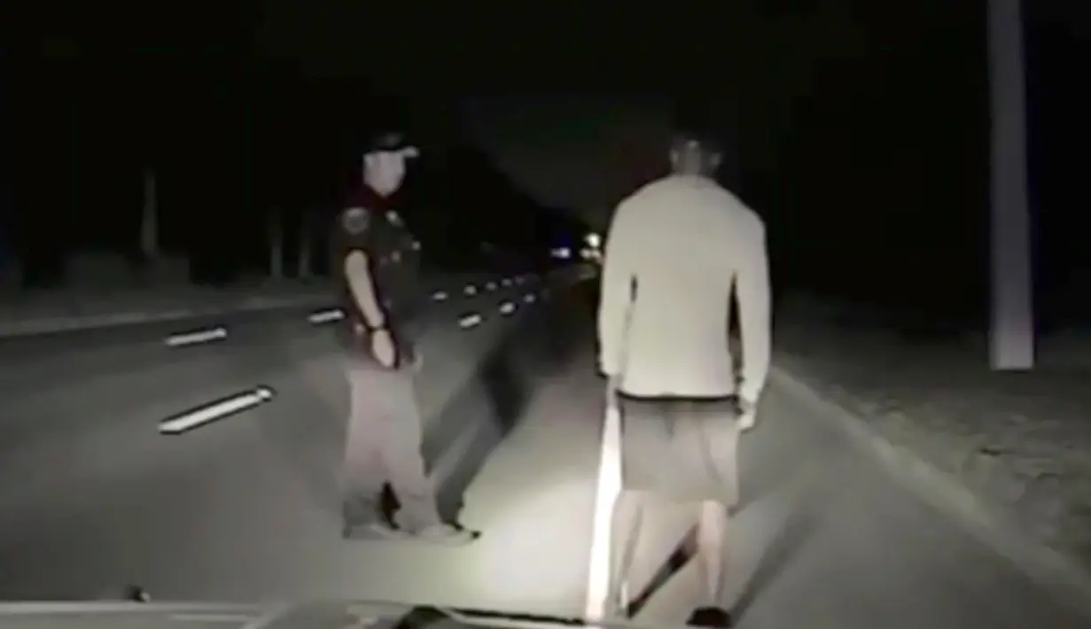 Polisi Jupiter, Florida melakukan tes mabuk terhadap pegolf Tiger Woods dengan berjalan mengikuti garis lurus di jalan, 29 Mei 2017. Tiger Woods harus berurusan dengan pihak kepolisian karena menyetir dalam keadaan mabuk (Jupiter Police Department/via AP)