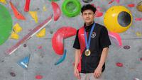 Atlet panjat tebing Indonesia, Veddriq Leonardo berfoto dengan medali emas Olimpiade Paris 2024 di markas FPTI, Hotel Santika Premier, Bekasi, Selasa (20/08/2024). (Bola.com/Bagaskara Lazuardi)