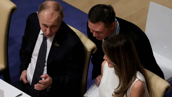 Vladimir Putin duduk di samping Melania Trump dalam acara makan malam KTT G20 di Hamburg, Jerman (7/7/2017). (AFP)