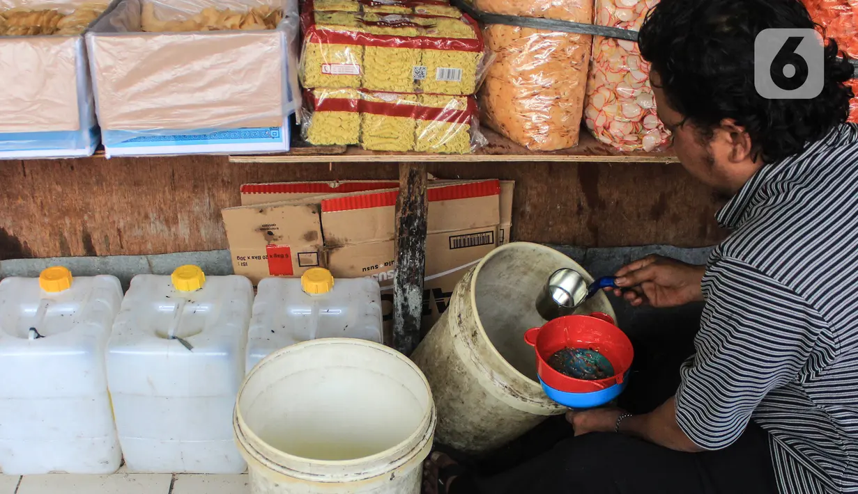 Pedagang memasukkan minyak goreng curah ke dalam kantong plastik di Pasar Kebayoran, Jakarta, Selasa (31/5/2022). Kementerian Perindustrian mencabut subsidi minyak goreng curah kepada pelaku usaha mulai Selasa (31/5/2022). (Liputan6.com/Johan Tallo)