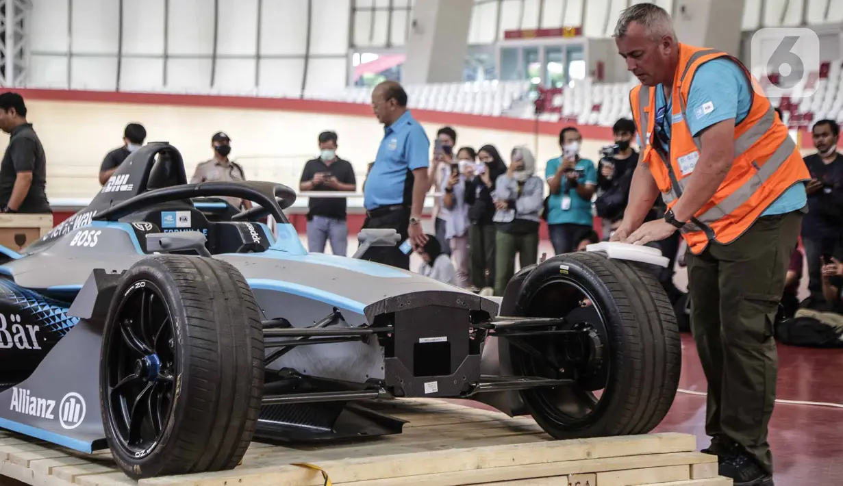 Panitia membuka kemasan replika mobil Formula E untuk kali pertama di Stadion Balap Sepeda Velodrome, Rawamangun, Jakarta Timur, pada Kamis (26/5/2022). Ini merupakan replika salah satu mobil Formula E yang akan mengaspal di Sirkuit Ancol pada 4 Juni mendatang. (Liputan6.com/Faizal Fanani)
