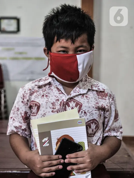 Siswa mengenakan masker saat mengikuti pembelajaran jarak jauh di Balai Warga Kelurahan Kuningan Barat, Mampang Prapatan, Jakarta, Kamis (27/8/2020). Kelurahan Kuningan Barat menyediakan fasilitas wifi gratis yang dapat digunakan para siswa. (merdeka.com/Iqbal S. Nugroho)