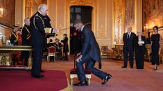 Mantan pesepak bola, David Beckham (kanan) dianugerahi gelar Ksatria oleh Raja Inggris, Charles III dalam upacara penobatan di Kastil Windsor, Berkshire, Inggris, Selasa (04/11/2025) waktu setempat. (AP Photo/PA/Jonathan Brady)