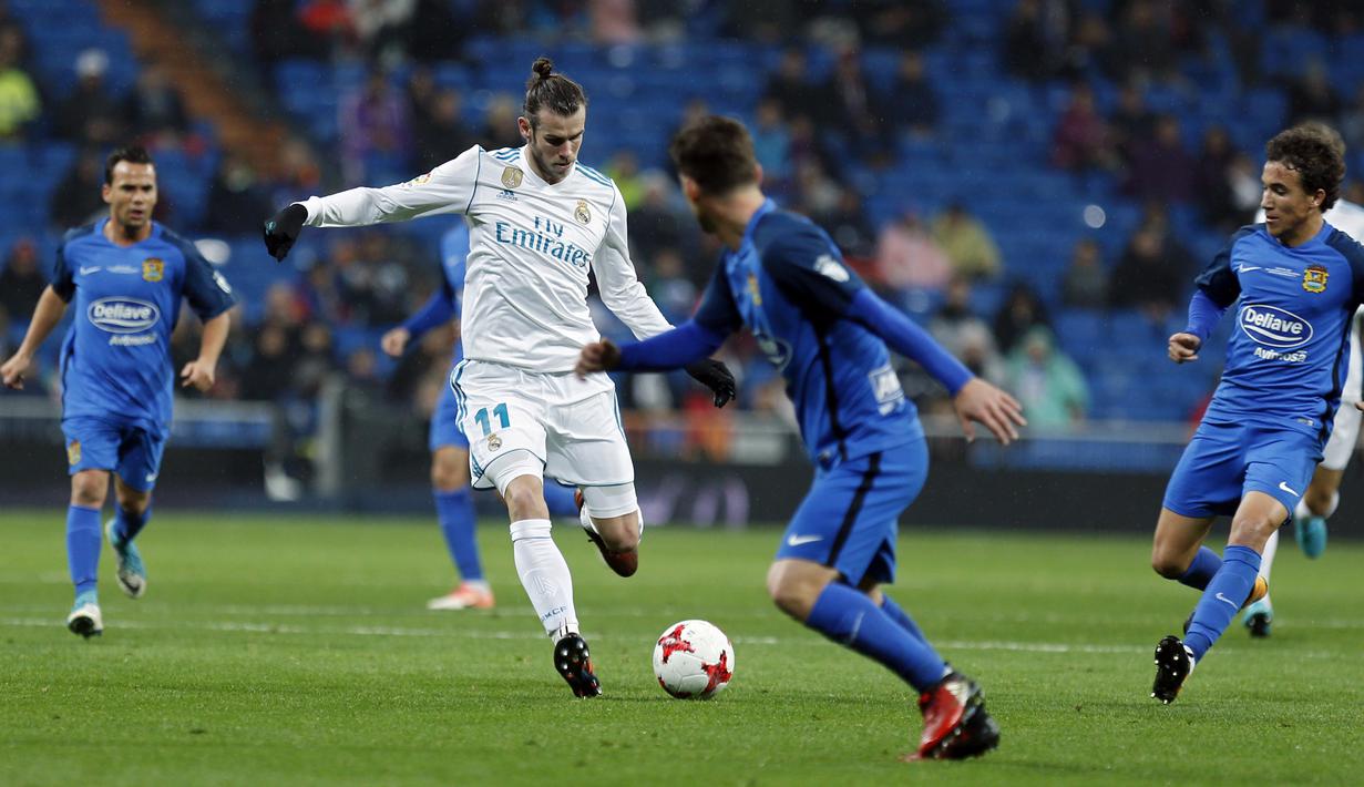 Pemain Real Madrid, Gareth Bale mencoba melepaskan tembakan melewati adangan para pemain Fuenlabrada pada laga Copa del Rey babak 32 besar di Santiago Bernabeu stadium, Madrid, (28/11/2017). Real Madrid bermain imbang 2-2. (AP/Francisco Seco)