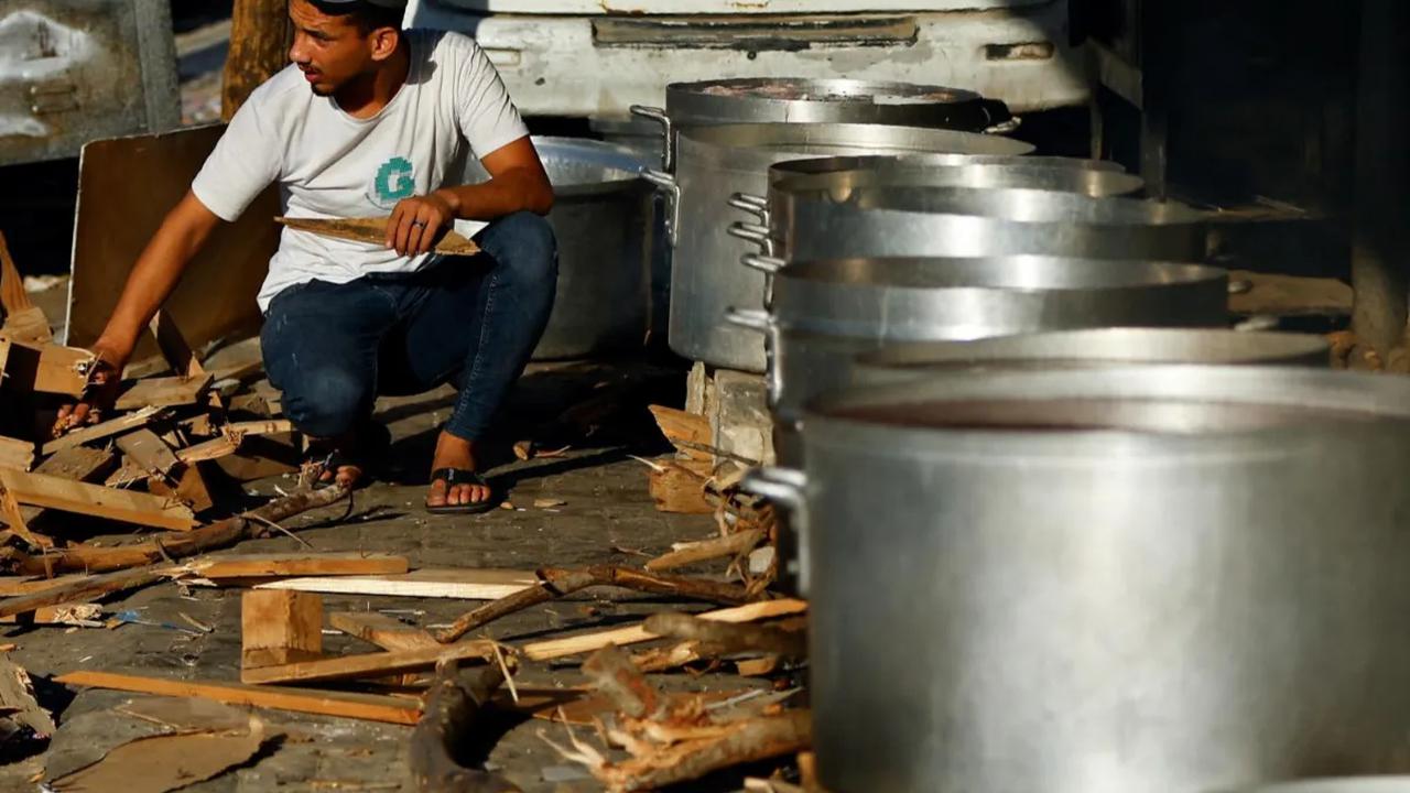 Warga Palestina memasak menggunakan kayu bakar di tengah kekurangan bahan bakar minyak dan gas di Khan Younis, di selatan Jalur Gaza (15/10/2023).<br>