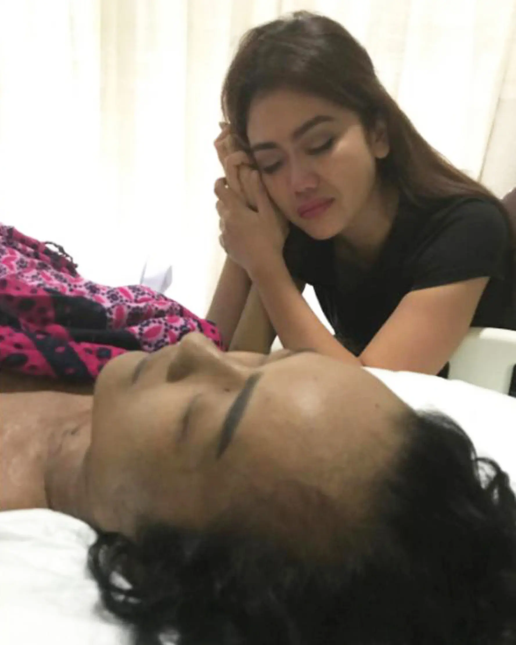 Anggia adik Julia Perez menggenggam tangan kakaknya yang sedang terbaring di RSCM, Jakarta. (Instagram/ anggitheperez)