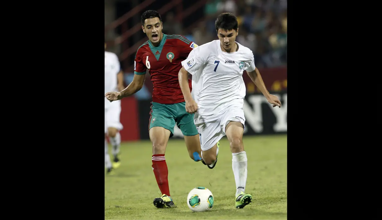 Pemain Timnas Maroko U-17, Sofyan Amrabat (kiri), berusaha mengejar pemain Uzbekistan U-17, Jamshid Boltaboev, dalam pertandingan Piala Dunia U-17 2013 yang berlangsung di Uni Emirat Arab, Senin (21/10/2013). Langkah Timnas Maroko U-17 harus terhenti di babak 16 besar setelah kalah 1-2  oleh Pantai Gading. (AFP/Karim Sahib)