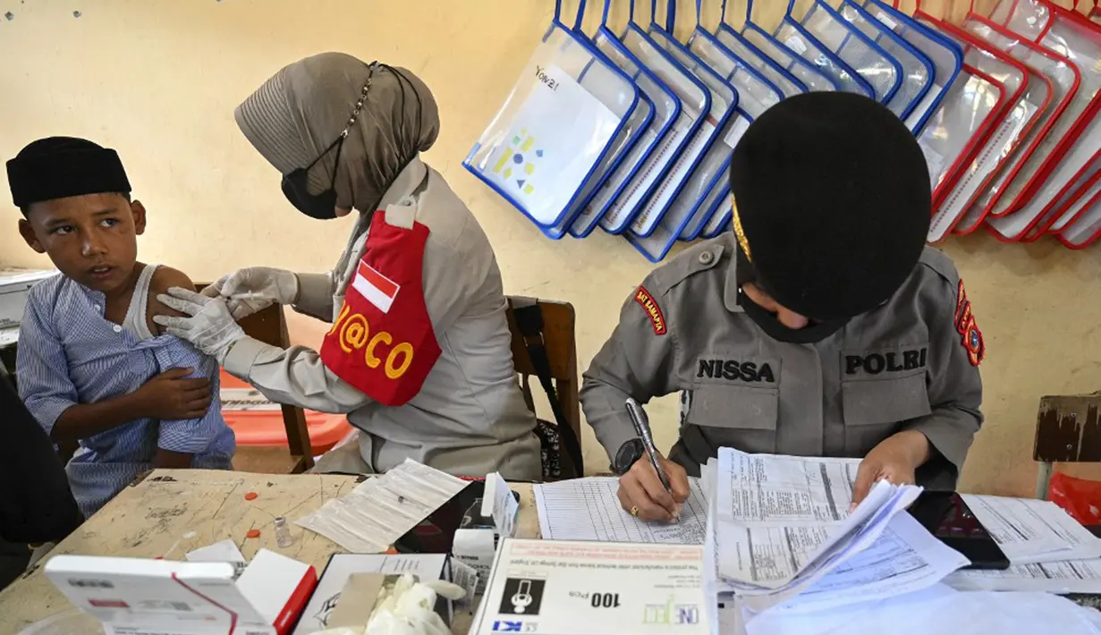 Seorang siswa menerima vaksin virus corona COVID-19 Sinovac di sebuah sekolah dasar di Darul Imarah, Kabupaten Aceh Besar, Provinsi Aceh, 14 Januari 2022. (CHAIDEER MAHYUDDIN/AFP)