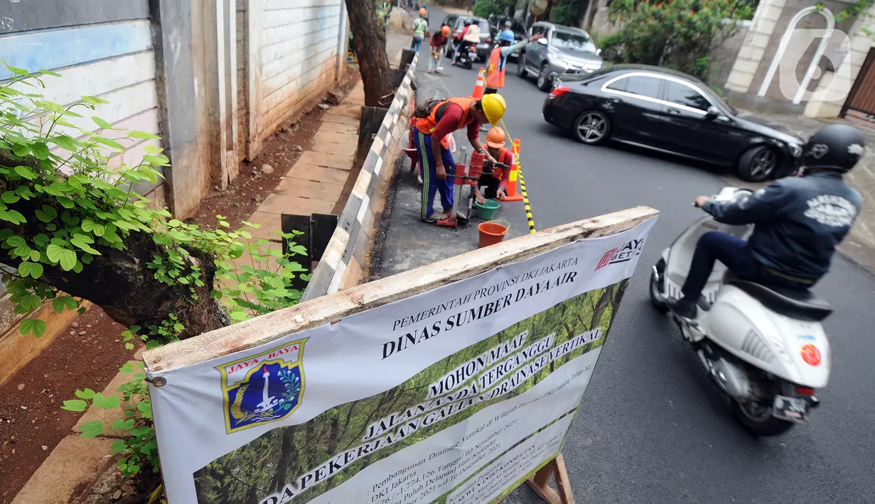 Kondisi lalu lintas saat pekerja mengebor aspal yang menutup sumur resapan di Jalan Lebak Bulus III, Cilandak, Jakarta Selatan, Senin (6/12/2021). Sebanyak 29 sumur resapan yang tertutup aspal kembali dilubangi agar bisa bisa menampung air saat curah hujan tinggi. (merdeka.com/Arie Basuki)