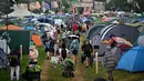 Pengunjung festival berjalan di tengah hujan melewati tenda pada hari pertama festival Glastonbury di desa Pilton, di Somerset, Inggris barat daya, pada 21 Juni 2023. (AFP/Oli Scarff)