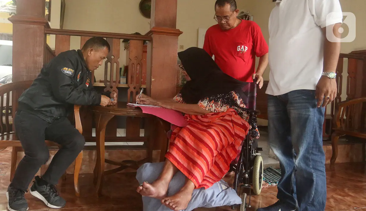 Petugas dari Kantor Pertanahan Kota Administrasi Jakarta Selatan menyerahkan sertifikat tanah kepada warga Jati Padang yang sedang sakit, Jakarta, Selasa (31/1). BPN Jaksel menyambangi rumah warga yang lanjut usia atau sedang sakit untuk menyerahkan sertifikat tanah. (merdeka.com/Arie Basuki)