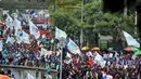 Terlihat ribuan buruh berjalan kaki dengan mengenakan kaos dan membawa bendera dari berbagai organisasi buruh, Kamis (1/5/14). (Liputan6.com/Johan Tallo)