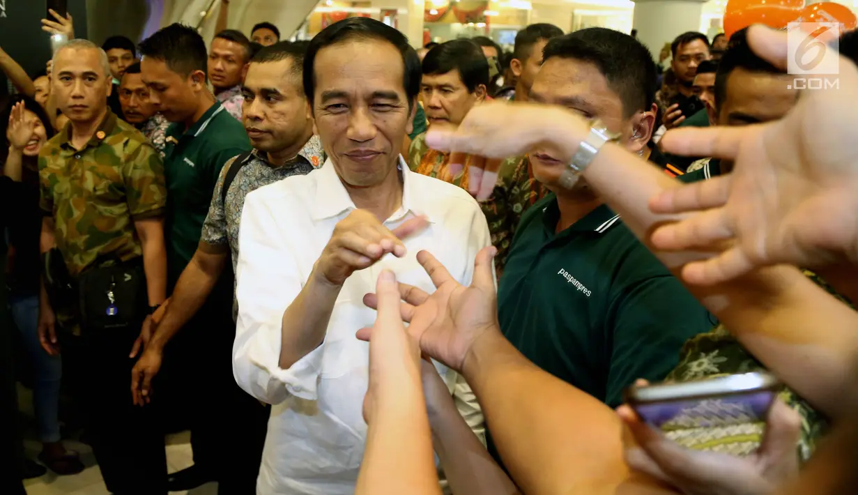 Presiden Joko Widodo menyalami warga ketika tiba di Sun Plaza Medan, Sumatera Utara, Jumat (24/11). Jokowi tiba mengenakan kemeja putih lengan panjang dan celana hitamnya sambil menebar senyum. (Liputan6.com/Johan Tallo)