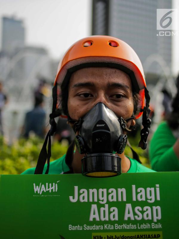 Anggota Walhi Jakarta menggunakan masker saat menggelar aksi melawan asap dan peduli satwa dalam CFD di Bundaran HI, Jakarta, Minggu (15/9/2019). Walhi menuntut pemerintah segera menyelesaikan permasalahan kebakaran hutan yang berdampak buruk bagi manusia dan lingkungan. (Liputan6.com/Faizal Fanani)