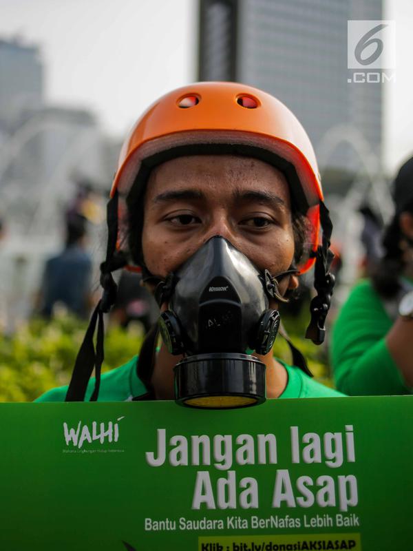 Anggota Walhi Jakarta menggunakan masker saat menggelar aksi melawan asap dan peduli satwa dalam CFD di Bundaran HI, Jakarta, Minggu (15/9/2019). Walhi menuntut pemerintah segera menyelesaikan permasalahan kebakaran hutan yang berdampak buruk bagi manusia dan lingkungan. (Liputan6.com/Faizal Fanani)