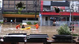 Petugas mengevakuasi warga menggunakan perahu karet saat melintasi banjir yang merendam kawasan Benhil, Jakarta, Selasa (25/2/2020). Hujan yang mengguyur wilayah tersebut membuat air sungai meluap sehingga menyebabkan Banjir setinggi pinggang orang dewasa. (Liputan6.com/Angga Yuniar)