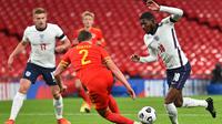 Bek Inggris, Ainsley Maitland-Niles, berebut bola dengan bek Wales, Chris Gunter, pada laga persahabatan di Stadion Wembley, Jumat (9/10/2020) dini hari WIB. Inggris menang 3-0 atas Wales. (AFP/Glyn Kirk/pool)