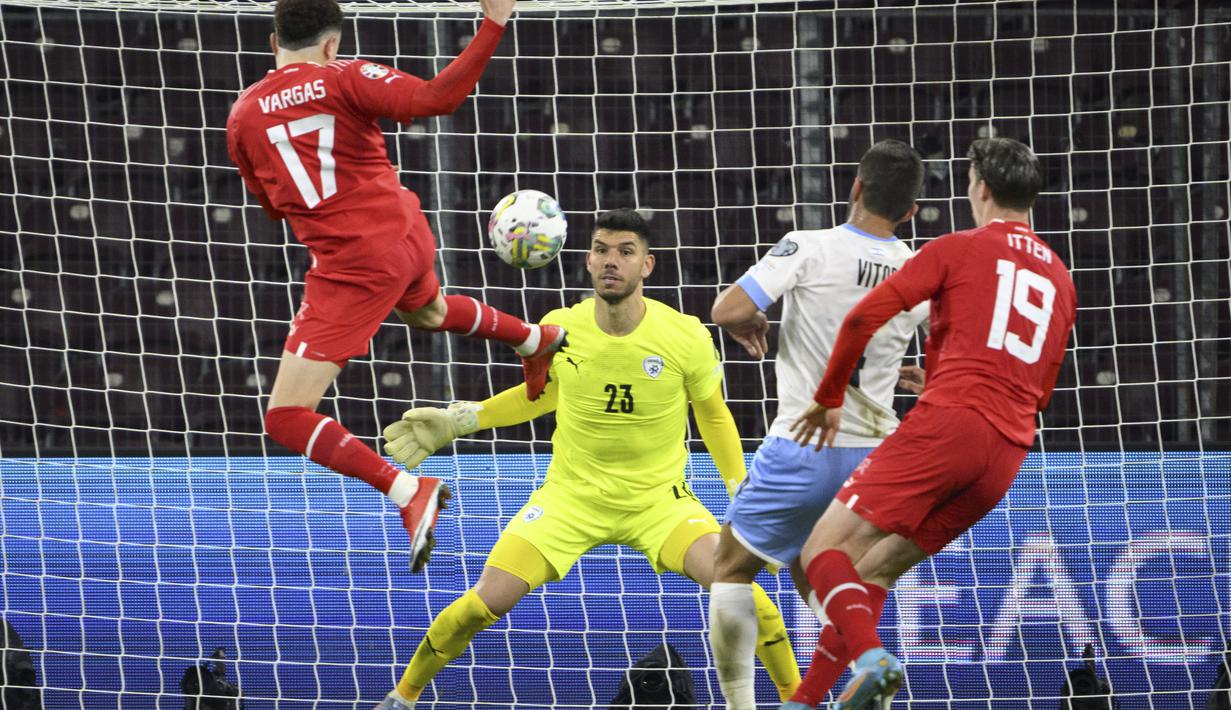 Gelandang Swiss, Ruben Vargas (kiri) mencetak gol melewati kiper Israel Omri Glazer dan Miguel Vitor di matchday kedua Grup I Kualifikasi Piala Eropa 2024 di Stade de Geneve, di Jenewa, Swiss, Rabu, 29 Maret 2023. (Salvatore Di Nolfi/Keystone via AP)