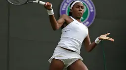 Petenis Cori Gauff berusaha mengembalikan bola pukulan Venus Williams selama pertandingan babak pertama Grand Slam Wimbledon di All England Lawn Tennis and Croquet Club, London (1/7/2019). Cori merupakan petenis AS berusia 15 tahun yang berhasil mengalahkan Venus Williams. (AP Photo/Tim Ireland)