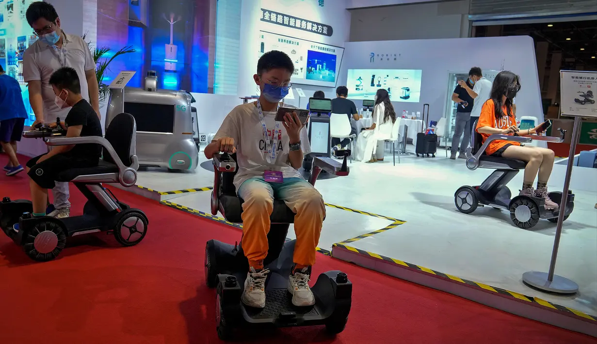 Anak-anak yang mengenakan masker mencoba kursi roda jarak jauh saat Konferensi Robot Dunia di Yichuang International Conference and Exhibition Centre, Beijing, China, 18 Agustus 2022. (AP Photo/Andy Wong)