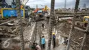 Para pekerja sedang memasangkan besi yang digunakan untuk pondasi jalan di kawasan Latumenten, Jakarta, Senin (05/12). Perbaikan jalan dengan mengganti pondasi baru tersebut guna memperkuat ketahanan badan jalan. (Liputan6.com/Faizal Fanani)