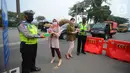 Pegawai BTN membagikan makanan dan hand sanitizer kepada petugas yang menjaga area penyekatan di kawasan Samsat Daan Mogot, Jakarta, Kamis (22/07/2021). BTN telah menyalurkan dana Bansos dalam meringankan beban rakyat terdampak pandemi Covid-19. (Liputan6.com) 