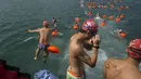 Perenang menyelam sebelum lomba renang lintas pelabuhan di Hong Kong, Minggu (18/10). 2.500 orang ambil bagian dalam menembus jarak lintasan laut sejauh 1,5 km dari Sam Ka Tsuen Public Pier ke Quarry Bay Park Public Pier. (REUTERS/Tyrone Siu)