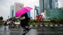 Warga berjalan sambil menggunakan payung saat Car Free Day (CFD) di kawasan Bundaran HI, Jakarta, Minggu (2/10/2022). Meski diguyur hujan deras sejak pagi, warga tetap antusias untuk tetap berolahraga saat CFD. (Liputan6.com/Faizal Fanani)