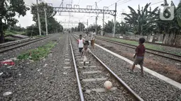 Anak-anak saat bermain di dekat rel kereta api di kawasan Bahari Ujung, Tanjung Priok, Jakarta Utara, Selasa (24/5/2022). Minimnya fasilitas dan ruang terbuka hijau di kawasan tersebut menyebabkan anak-anak setempat memilih bermain di sekitar perlintasan kereta api yang dapat membahayakan keselamatan mereka. (merdeka.com/Iqbal S Nugroho)