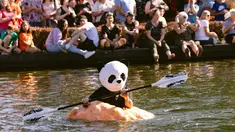 Jason Springs mengenakan kostum panda sambil mendayung labu raksasa menuju garis finish dalam event West Coast Giant Pumpkin Regatta di Tualatin, Oregon, Amerika Serikat pada 16 Oktober 2022. Peserta membuat labu dengan ukuran besar bisa mengambang dan ditumpangi satu orang untuk memenangkan lomba. (Photo by Wesley Lapointe / AFP)
