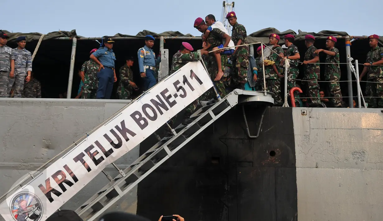 Anggota TNI membantu warga eks Gafatar menuruni tangga kapal saat tiba di Pelabuhan Tanjung Priok, Jakarta, Kamis (28/1/2016). Sebanyak 824 warga eks Gafatar dipulangkan dari Kalimantan untuk dikembalikan ke daerah asal. (Liputan6.com/Gempur M Surya)