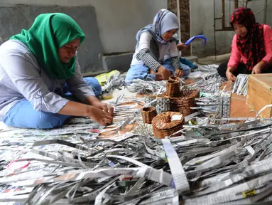 Sejumlah ibu membuat kerajinan tangan dari koran bekas di Kampung Sirnasari, Tanah Baru, Bogor, Rabu (13/2). Kegiatan industri rumahan tersebut melibatkan lebih dari 30 ibu di lingkungan RT yang sudah berjalan selama 6 tahun. (Merdeka.com/Arie Basuki)
