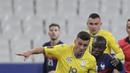 Penyerang Ukraina, Junior Moraes membawa bola dari kejaran gelandang Prancis, Ngolo Kante pada pertandingan kualifikasi Piala Dunia D di stadion Start de France, di Saint Denis, utara Paris, Kamis (25/3/2021). Prancis bermain imbang atas Ukraina 1-1. (AP Photo/Thibault Camus)