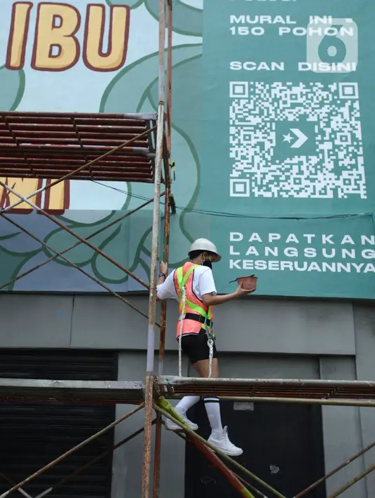 Muralis perempuan saat menyelesaikan pembuatan mural pada dinding di kawasan Juanda, Jakarta, Rabu (16/6/2021). Mural ini merupakan kegiatan kampanye Converese City Forests yang mengangkat tema Campaign Breaking Barries-True Color. (merdeka.com/Imam Buhori)