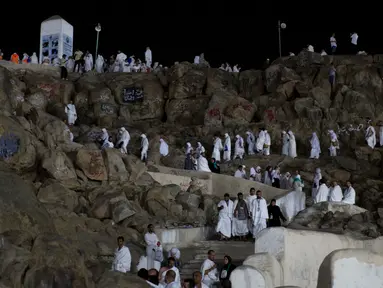 Jemaah calon haji berada di Bukit Jabal Rahmah, saat mereka tiba di Arafah untuk menjalani wukuf di luar kota suci Mekah, Arab Saudi (30/8).  Bukit Jabal Rahma dikenal sebagai bukit kasih sayang. (AP Photo / Khalil Hamra)