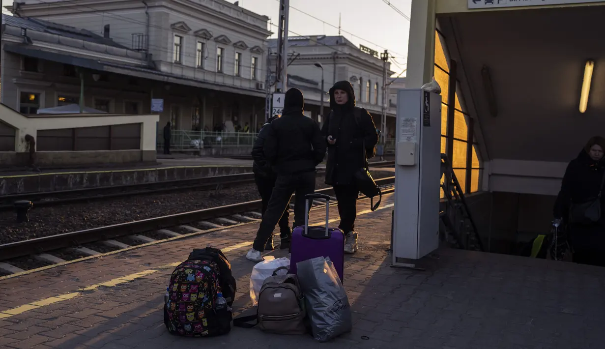 Orang-orang yang melarikan diri dari perang di Ukraina menunggu di stasiun kereta api di Przemysl, Polandia tenggara, Kamis (17/3/2022). Polandia telah menerima sekitar 1,95 juta pengungsi yang melarikan diri dari perang dan agresi Rusia di Ukraina. (AP Photo/Petros Giannakouris)