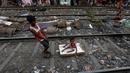 Ratan Mandal (10) bermain bersama adiknya, Bubai Tati, di rel kereta api di daerah kumuh Kolkata, India, 13 Maret 2016. Diperkirakan ada 1.000 warga yang tinggal di perkampungan kumuh di pinggir rel Kota Kolkata. (REUTERS/Rupak De Chowdhuri)