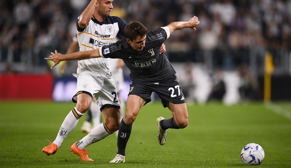 Pemain Juventus, Andrea Cambiaso (kanan) berebut bola dengan pemain Lecce, Alexis Blin pada laga lanjutan Liga Italia 2023/2024 di Allianz Stadium, Juventus, Italia, Rabu (27/09/2023). (AP Photo/LaPresse/Fabio Ferrari)