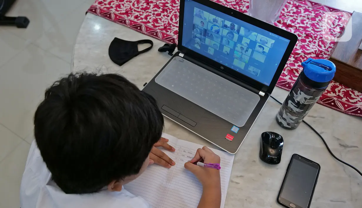 Siswa SD Islam Al Azhar 4 Muhammad Risyad (10) saat mengikuti kegiatan belajar mengajar secara daring dari kediamannya di Bintaro, Jakarta, Senin (13/7/2020). Memasuki tahun ajaran baru, kegiatan belajar mengajar diawali dengan perkenalan para siswa. (Liputan6.com/Herman Zakharia)