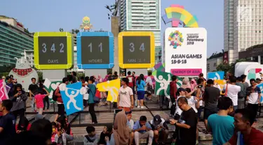 Warga memadati layar Countdown Asian Games 2018 saat Car Free Day di Bundaran HI, Jakarta, Minggu, (10/09). Layar Countdown Asian Games 2018  ini menandai hitung mundur untuk pelaksanaan Asian Games 2018. (Liputan6.com/Fery Pradolo)